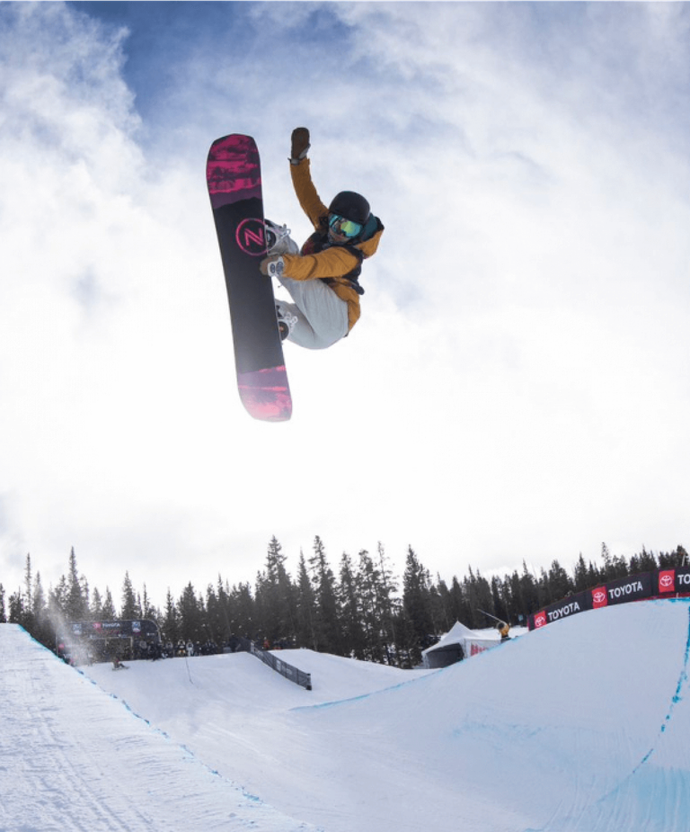 Snowboarder during half pipe competition jump